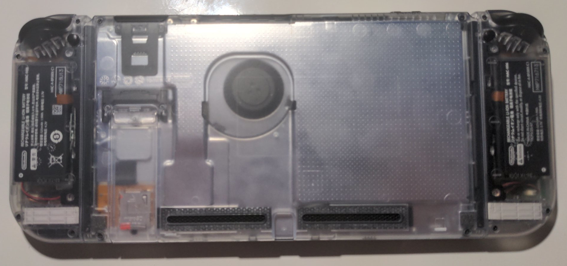 Back view of a Nintendo Switch with clear plastic shells on the joycons and console
